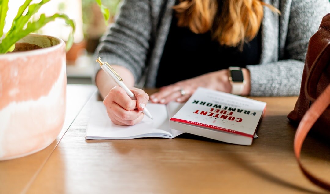 person writing goals in notebook